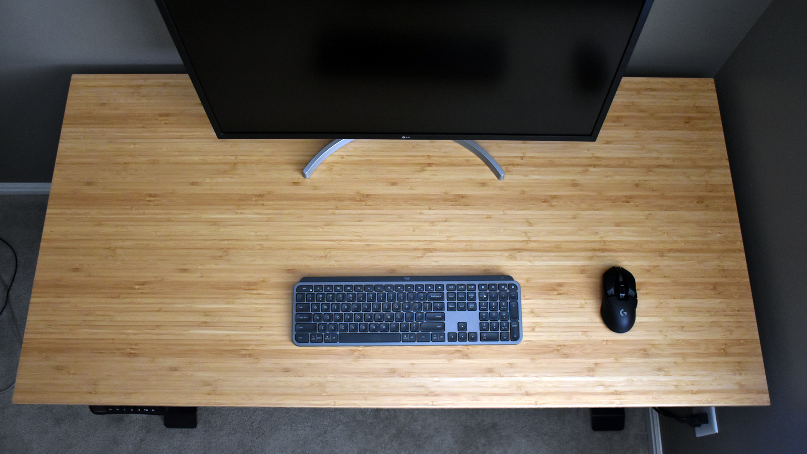 Top-down view of the desk with just a keyboard, monitor, and mouse on it