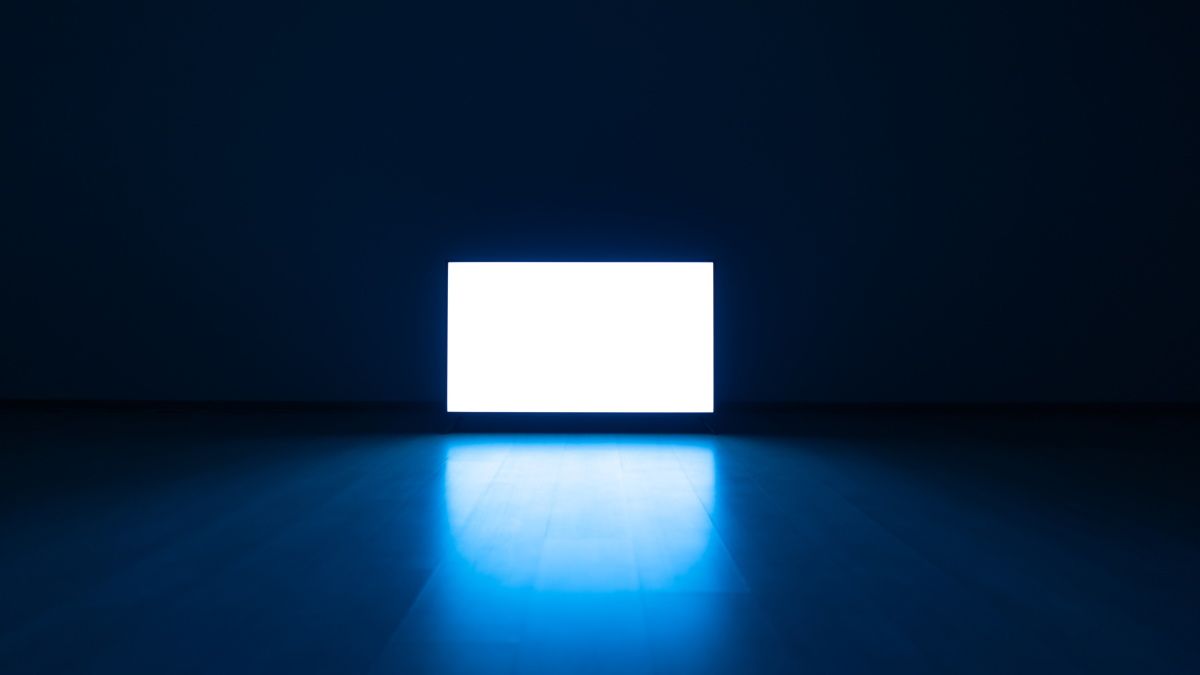 A bright television in a dark room.