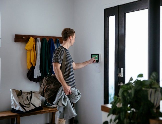 Man using touch-screen panel by front door
