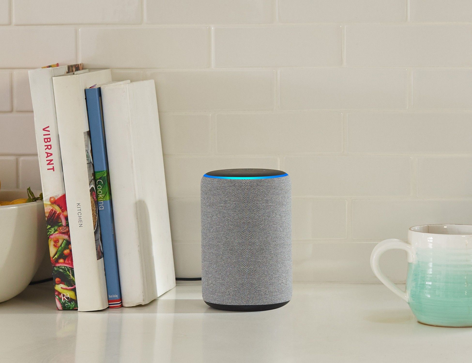 Echo Plus on counter with books and a coffee mug