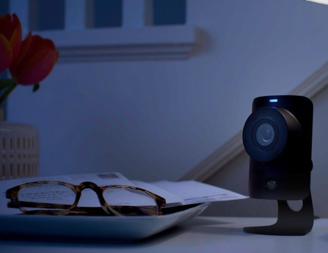 Camera next to glasses on table at night