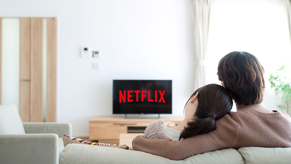Couple sitting on a couch watching Netflix on a TV