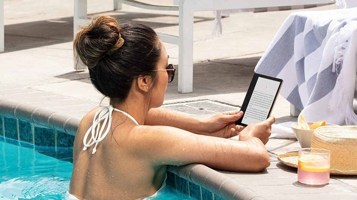 Person reading Kindle Oasis by the pool