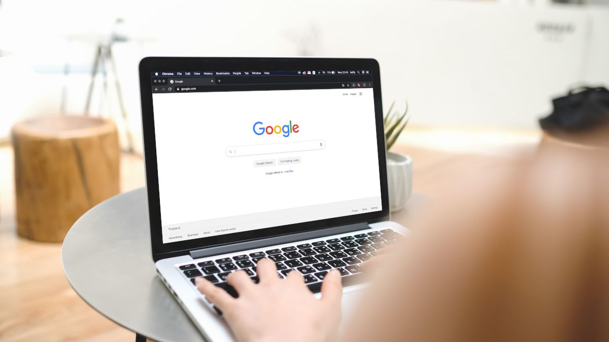 Woman typing on a laptop with Google search open in browser