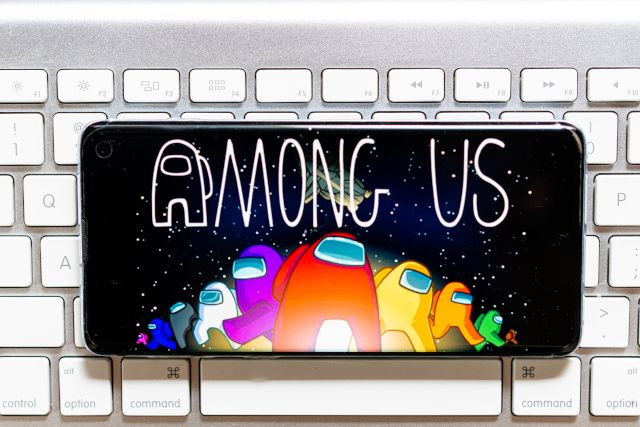 A smartphone on top of a keyboard with Among Us title screen