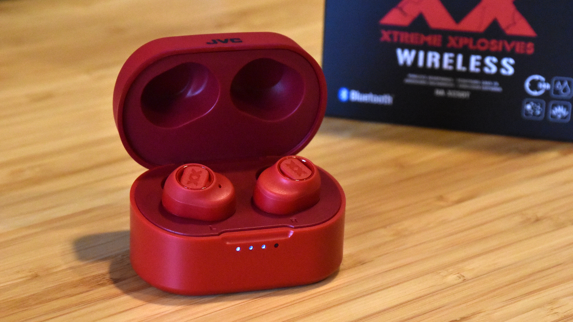 Shot of the HA-XC50Ts charging in the case with the lid open, with the packaging behind it