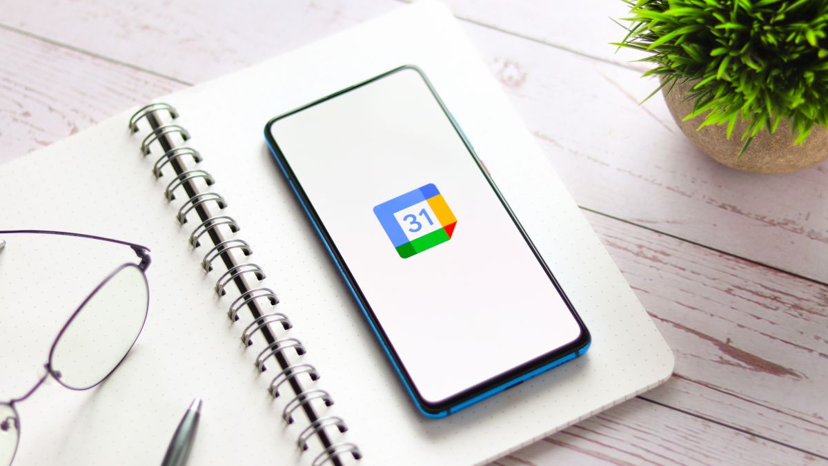 Smartphone on open planner with Google Calendar logo displayed