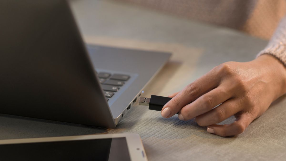 Woman's hand plugging a USB drive into a Macbook