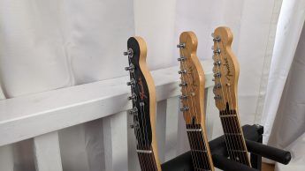 Indoor shot, a closeup of guitar headstocks in low light