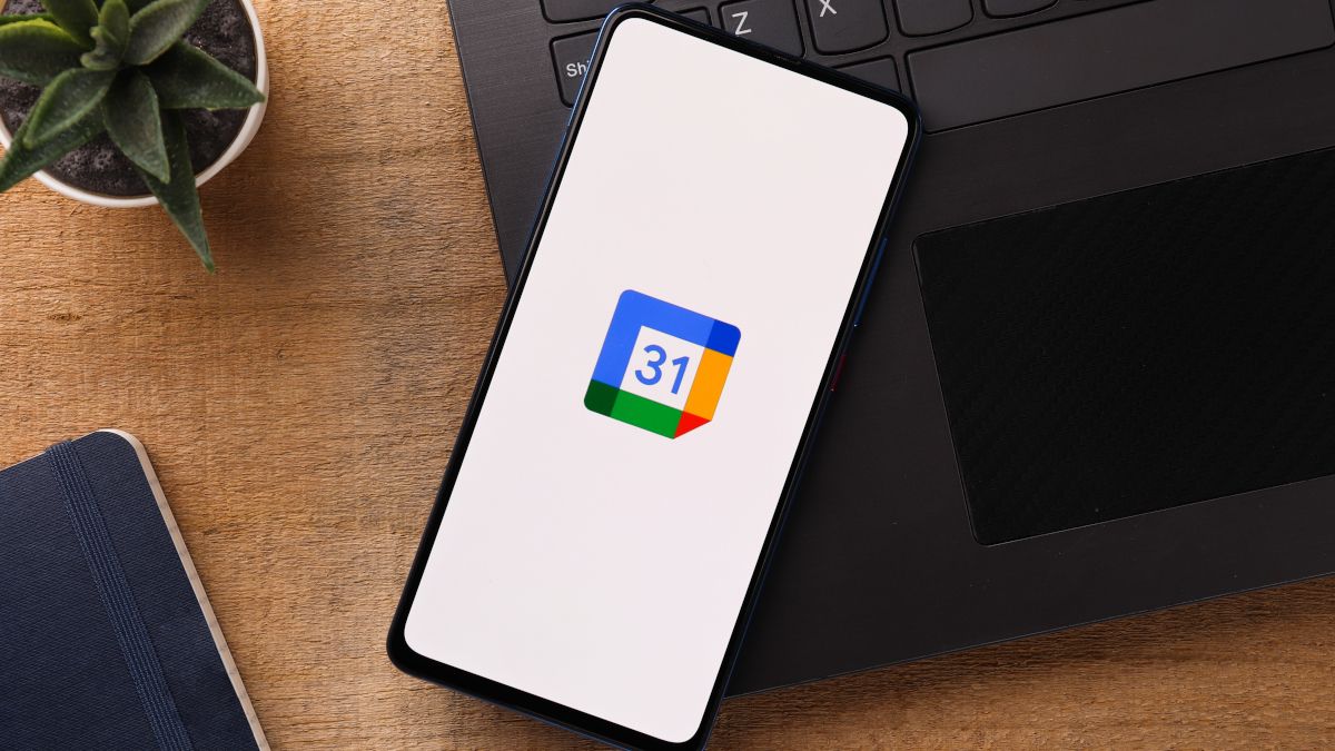 Smartphone on top of a laptop with the Google Calendar logo displayed