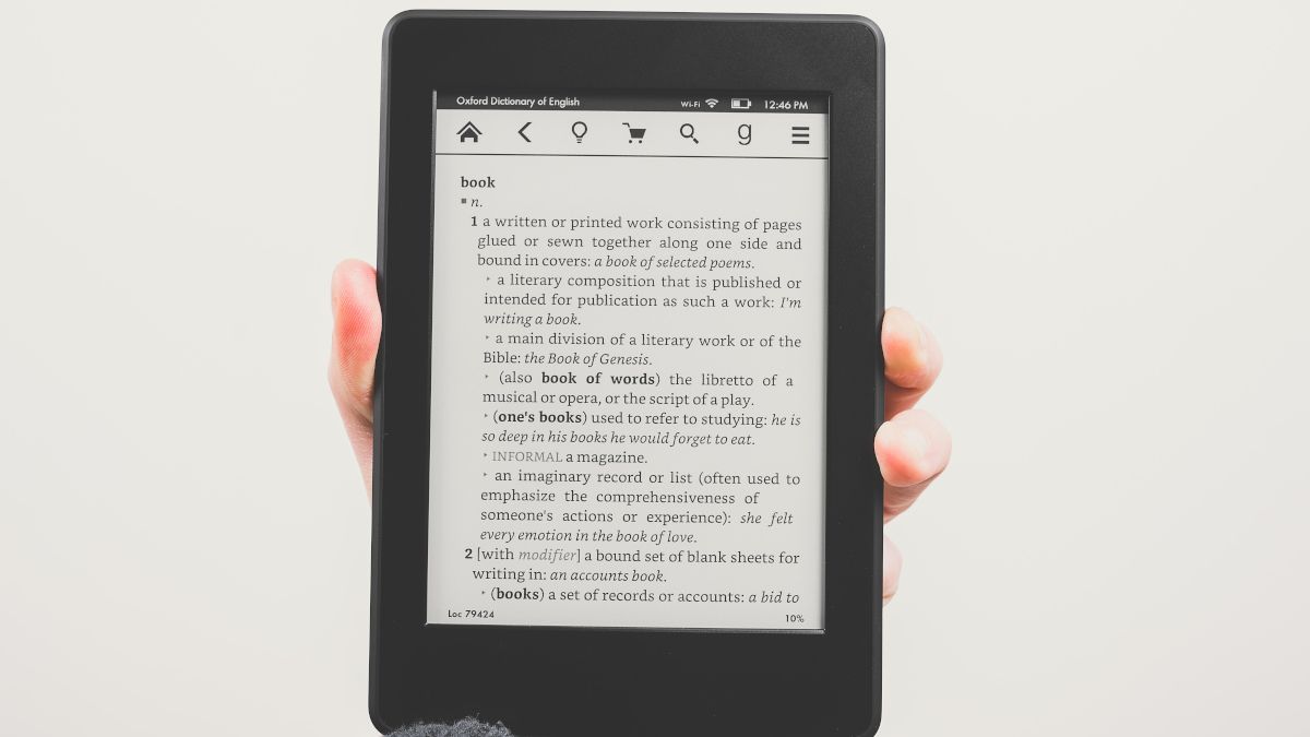 E-reader being held up by a hand and displaying the definition of 
