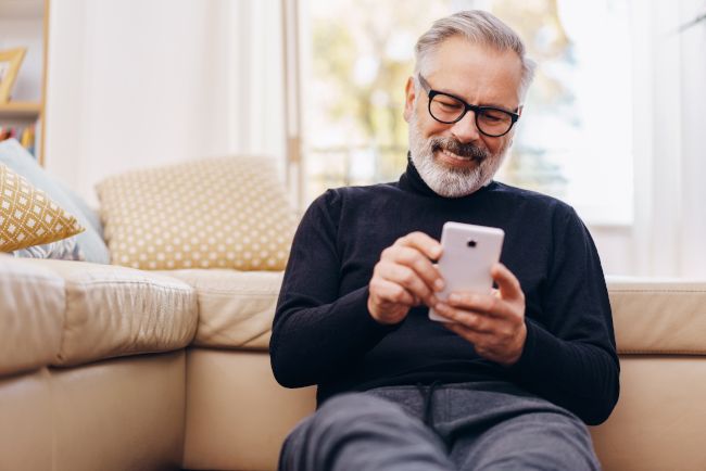 Man sitting and smiling at smartphone
