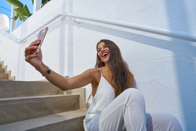 Young Latin woman smiling and looking up to take a selfie