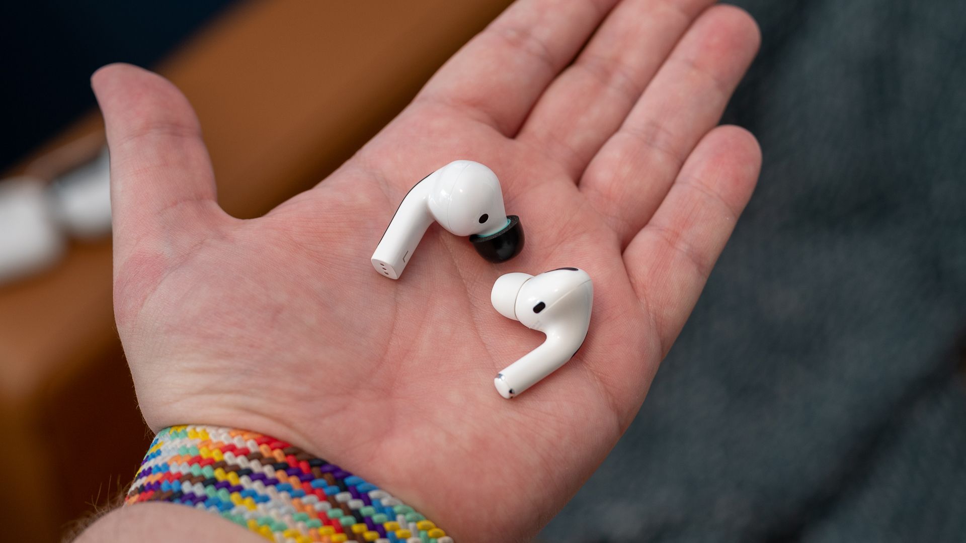 White earbuds in the palm of a hand