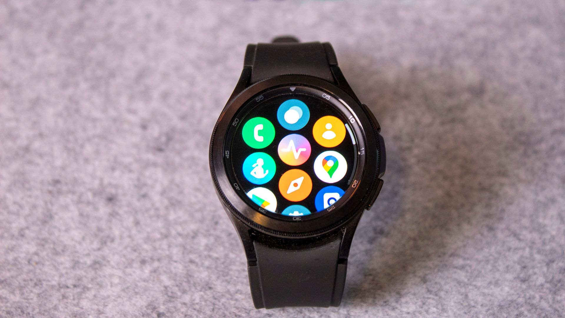 A Galaxy Watch 4 with Wear OS apps on the screen