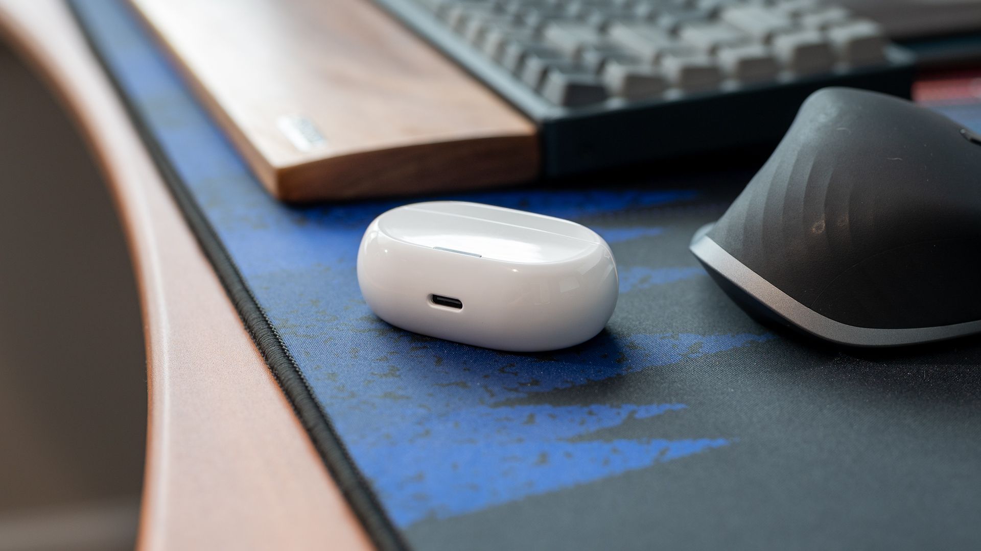 A white earbud case on a desk