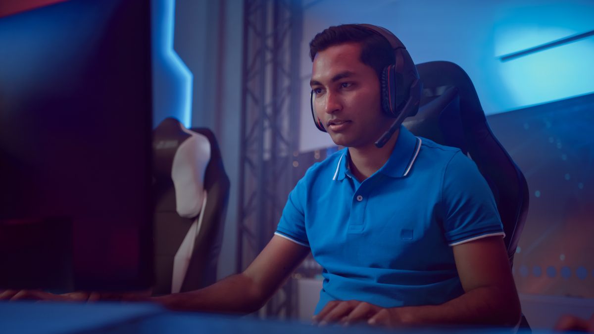 Male e-sports gamer wearing headset looking at monitor