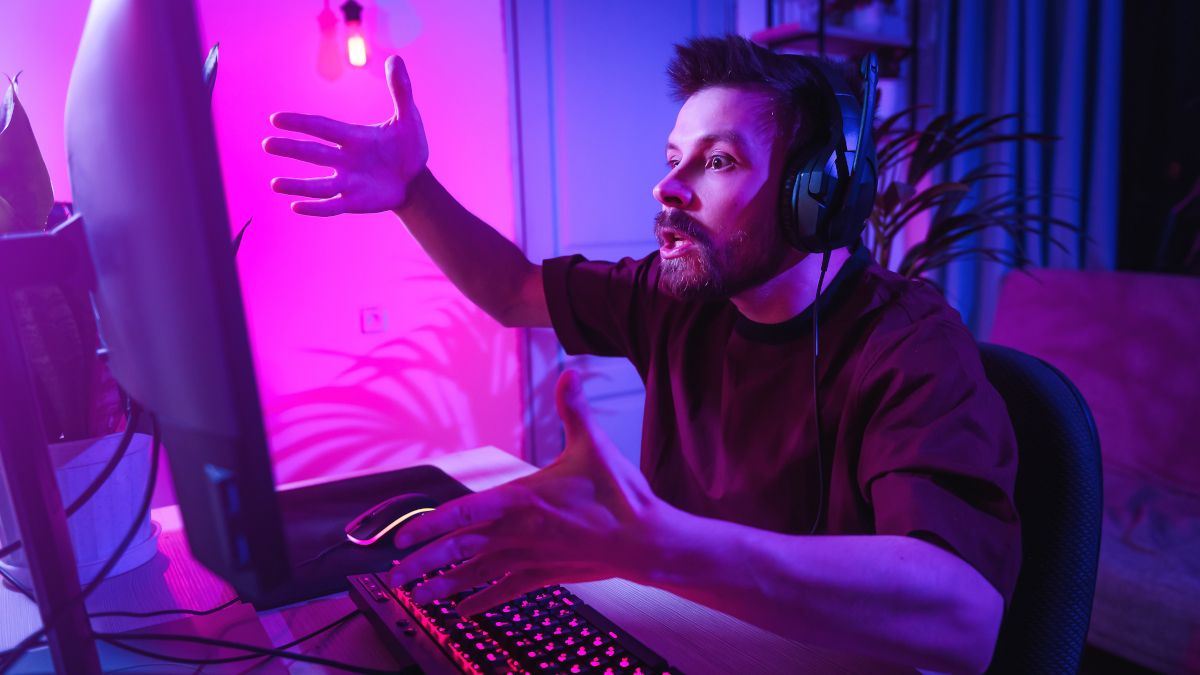 Male gamer looking upset at computer screen