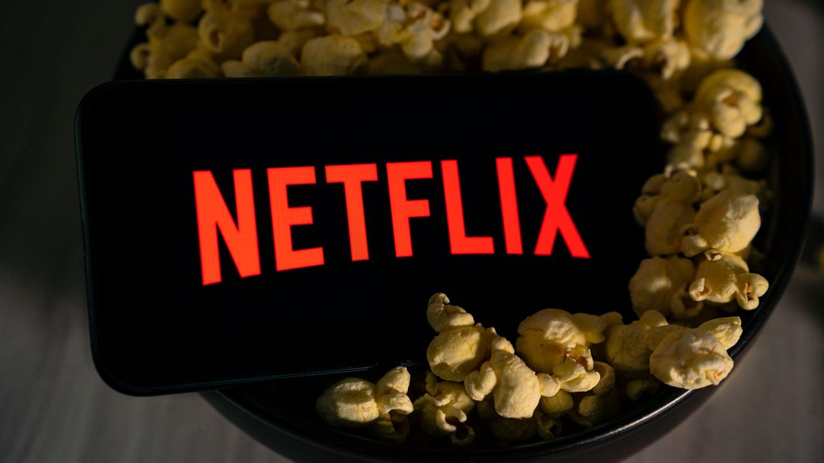Netflix logo on a smartphone sitting in a bowl of popcorn
