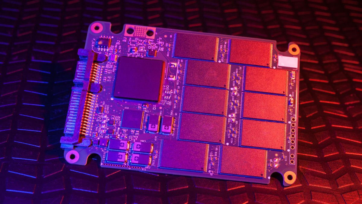SSD drive circuit board in blue and pink light.