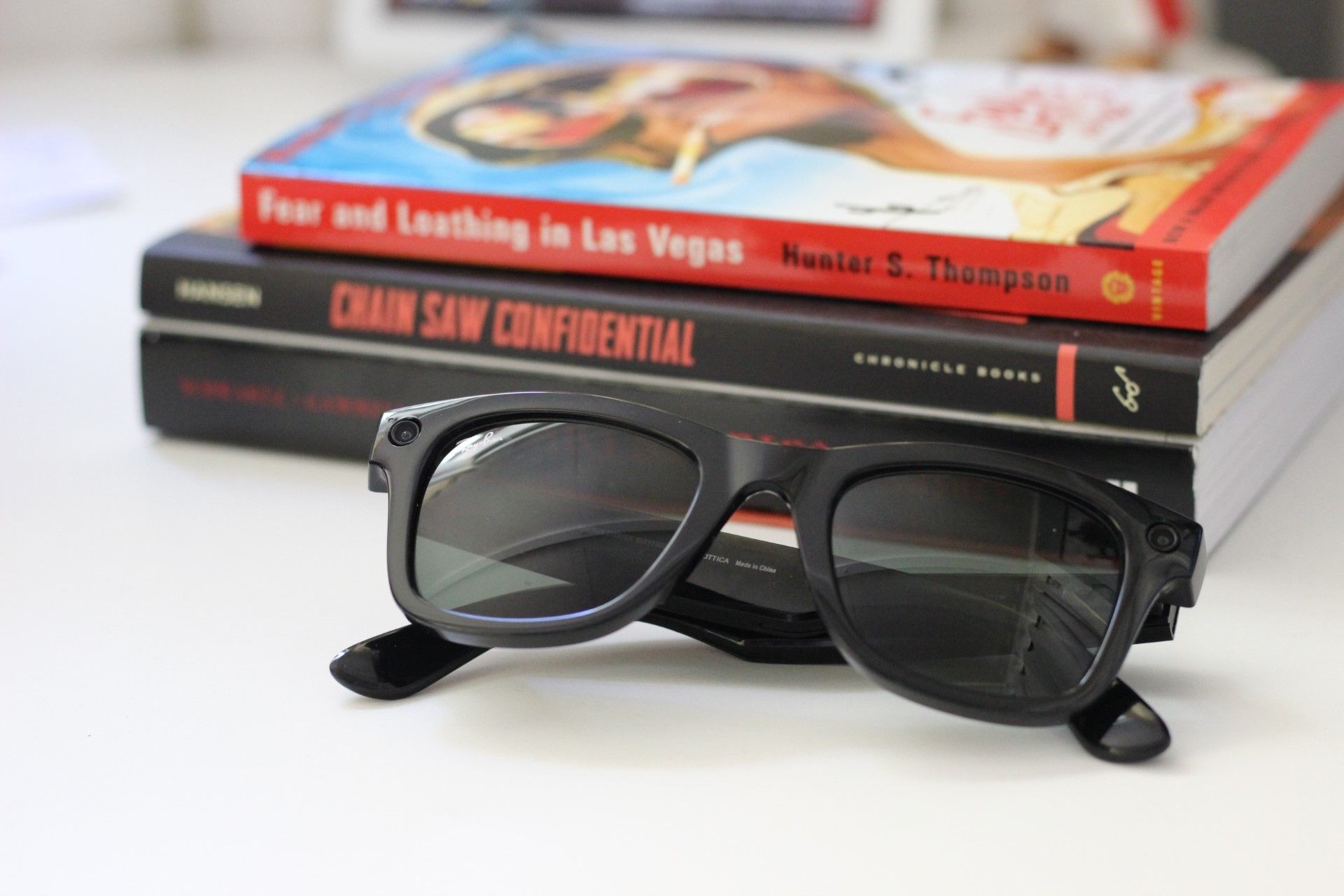 Ray-Ban Stories on a desk in front of some books
