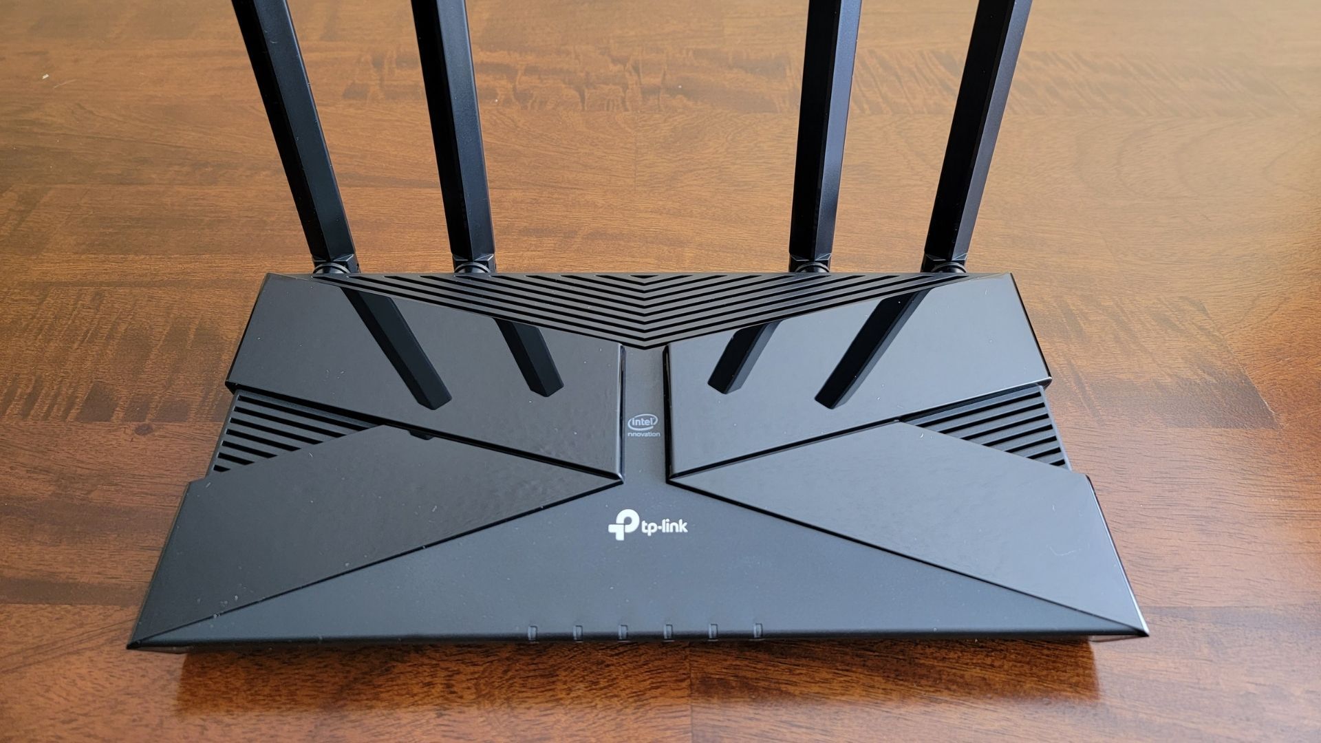 An overhead shot of the tp-link archer ax50 router by itself on a wooden table (1)