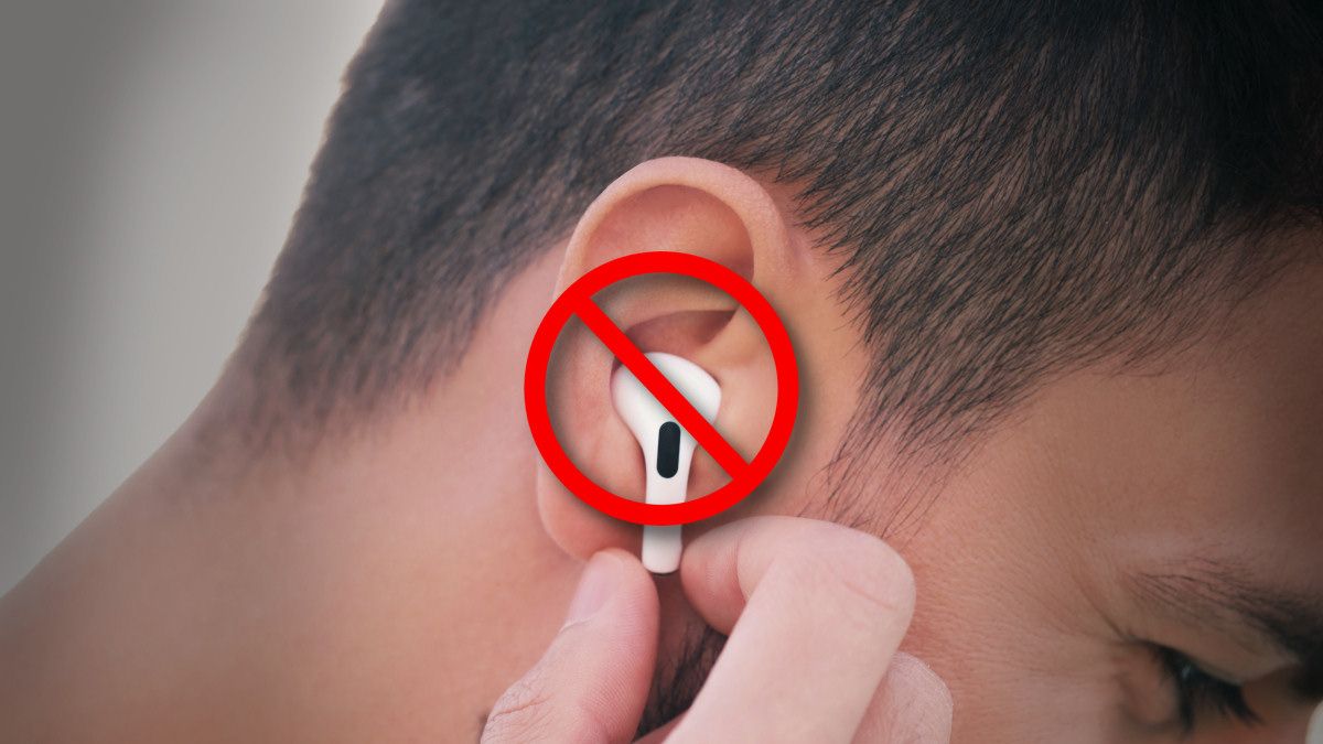 Person holding a crossed-out Apple Airpod in one ear.