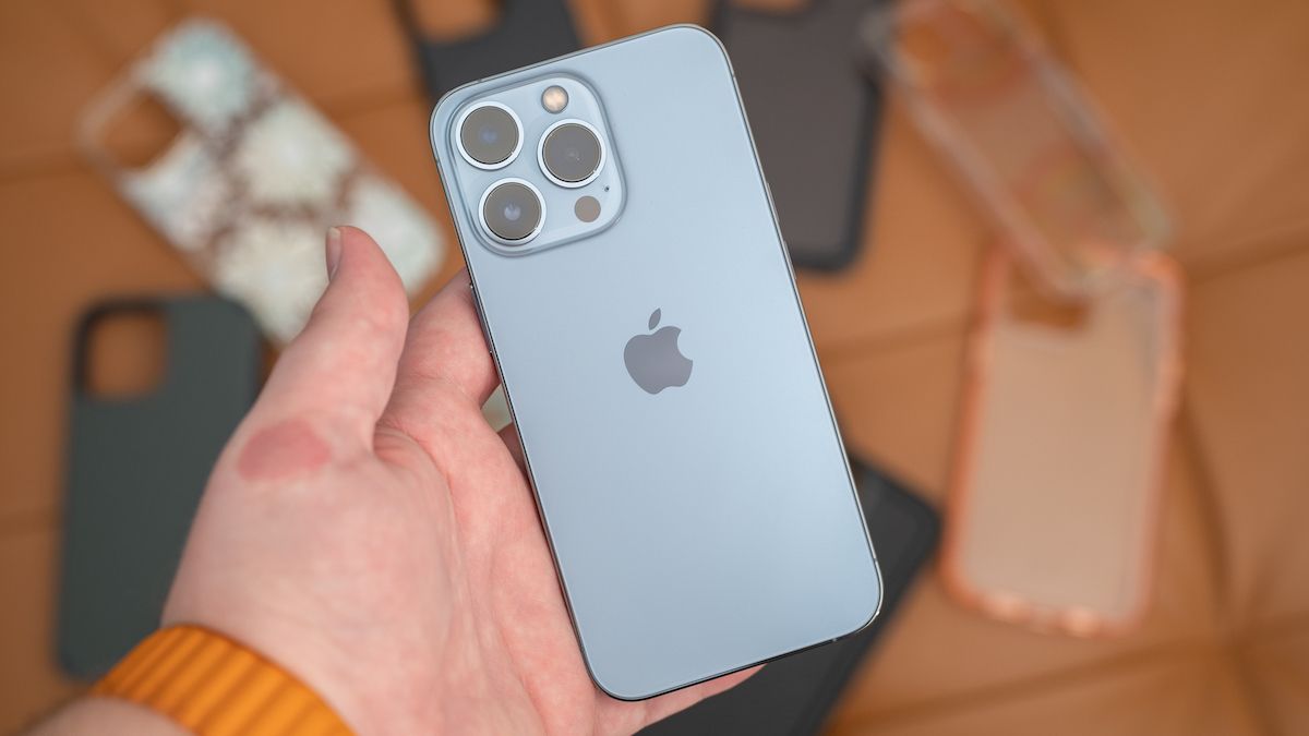 iPhone 13 Pro with cases in the background