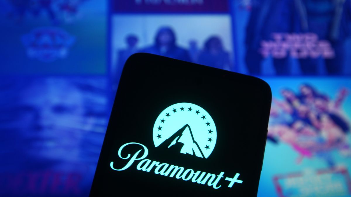Paramount+ logo on a smartphone in front of several media posters