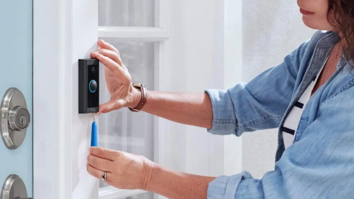 Person installing ring video doorbell wired