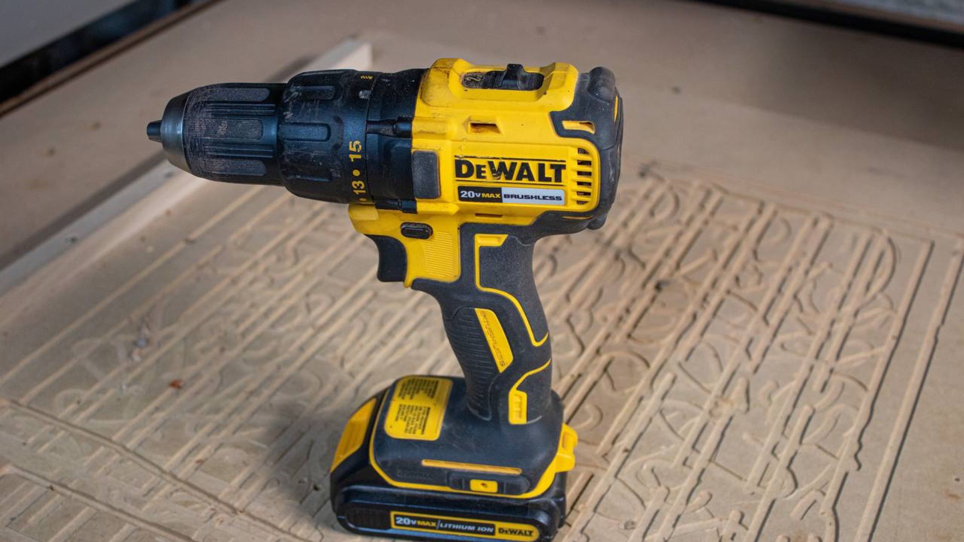 A DeWalt brushless, cordless drill sitting on a workshop table