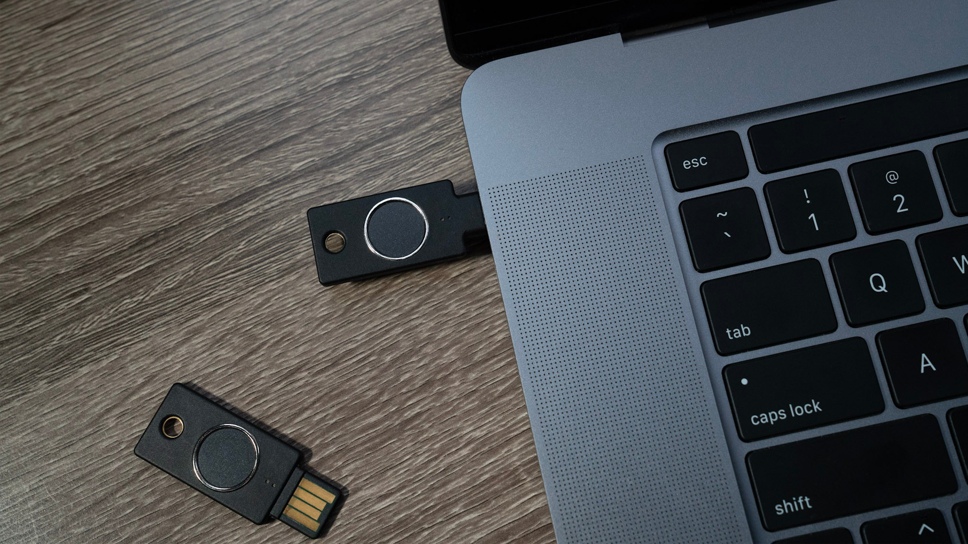 The USB-C key plugged into a laptop, top-down shot