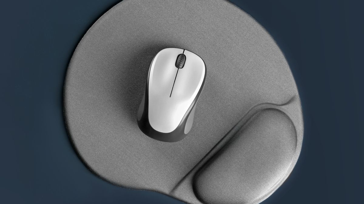 A mouse pad with a wrist rest and a wireless mouse on top of it.