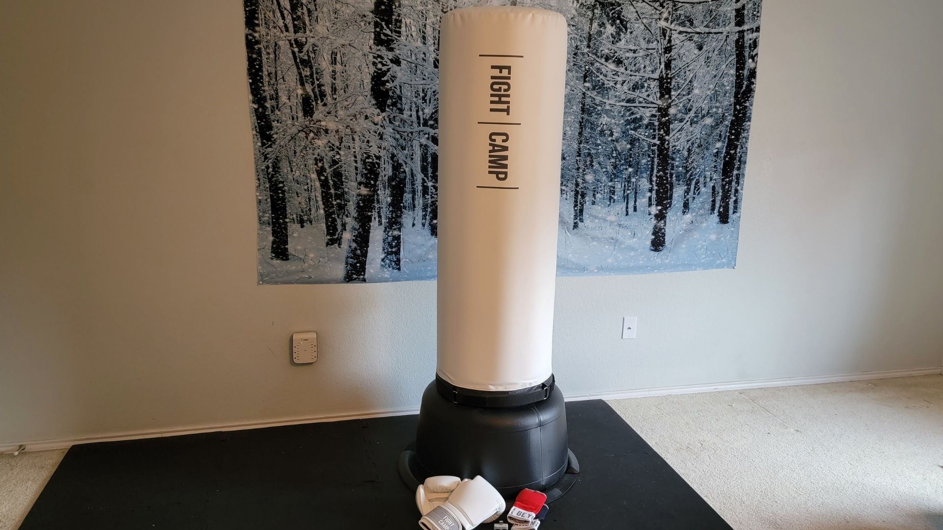 featured image of the fightcamp punching bag on the mat with the boxing gloves, quick trackers, and punch trackers laid out in front on a black workout mat