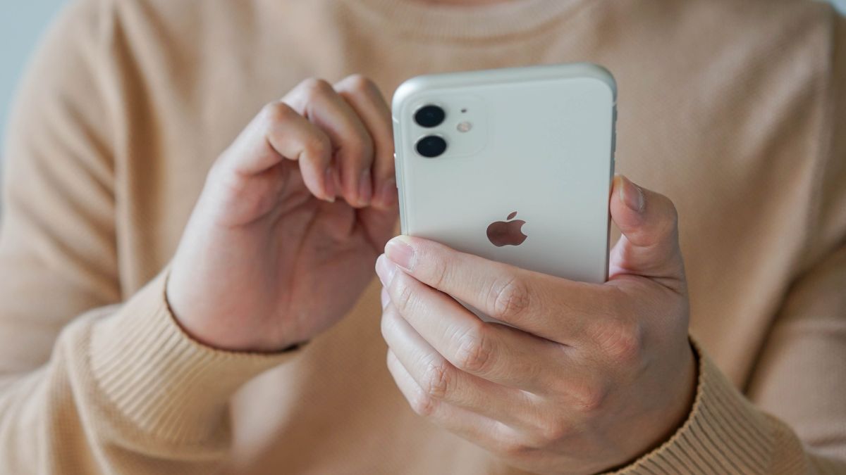 Closeup of a man's hands holding an iPhone 11.