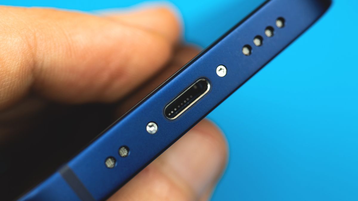 Closeup of a Lightning connector port on a blue iPhone 12 Mini
