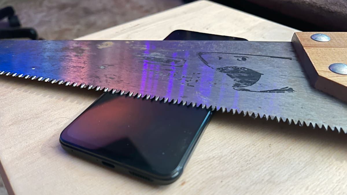 Hand saw on top of smartphone screen