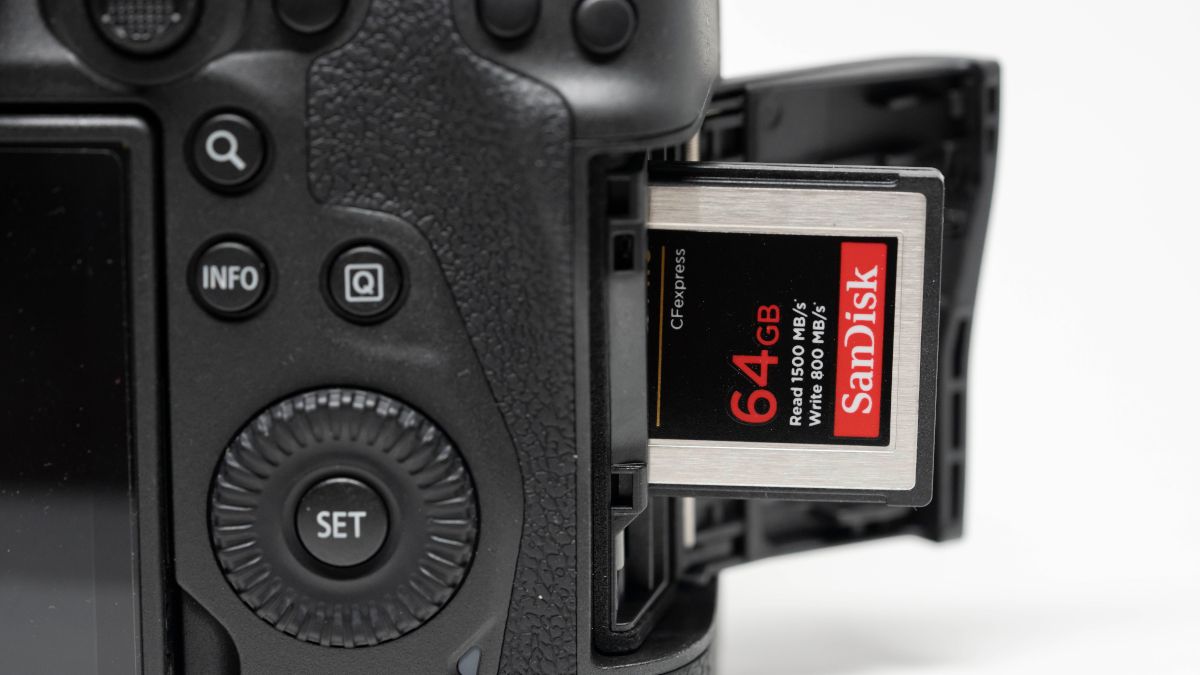 Closeup of a SanDisk CFExpress card being inserted into a camera.