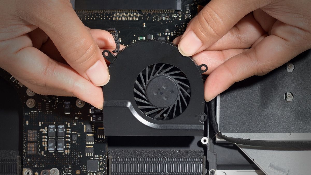 Someone installing a fan on a computer motherboard.