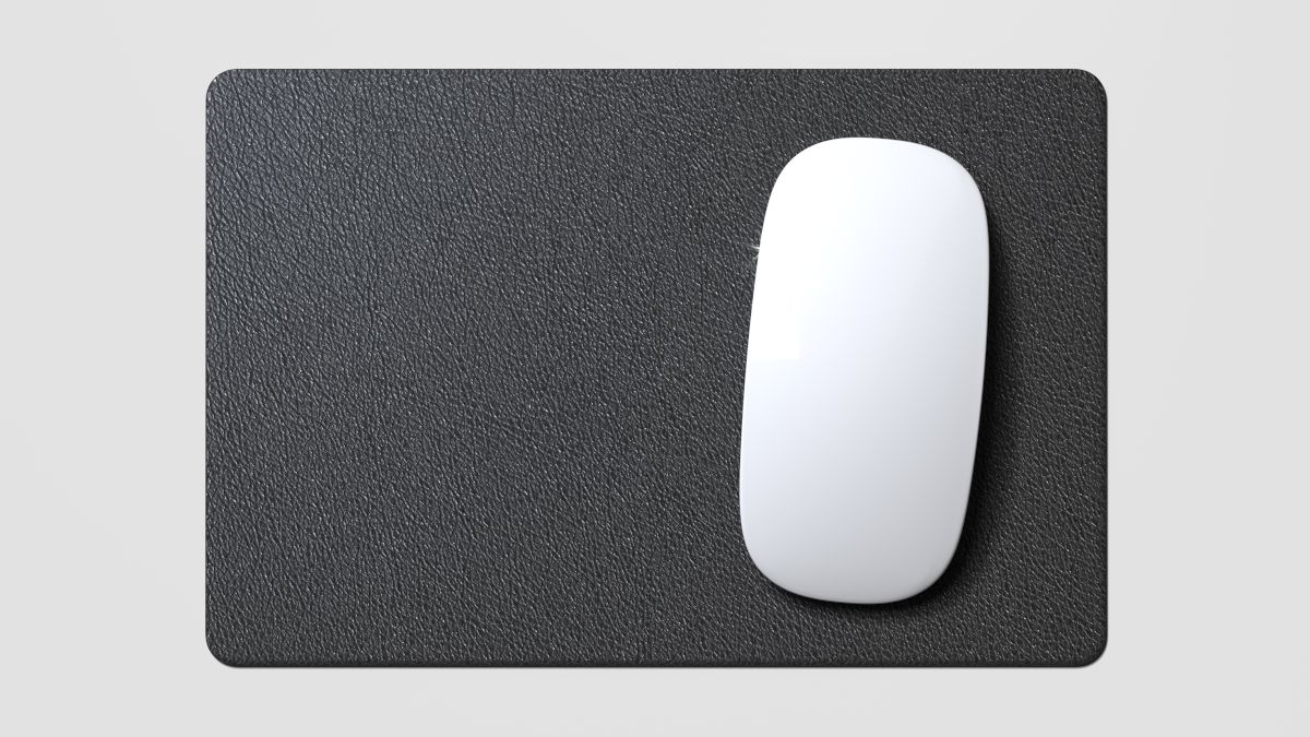 A white mouse on a black mouse pad.