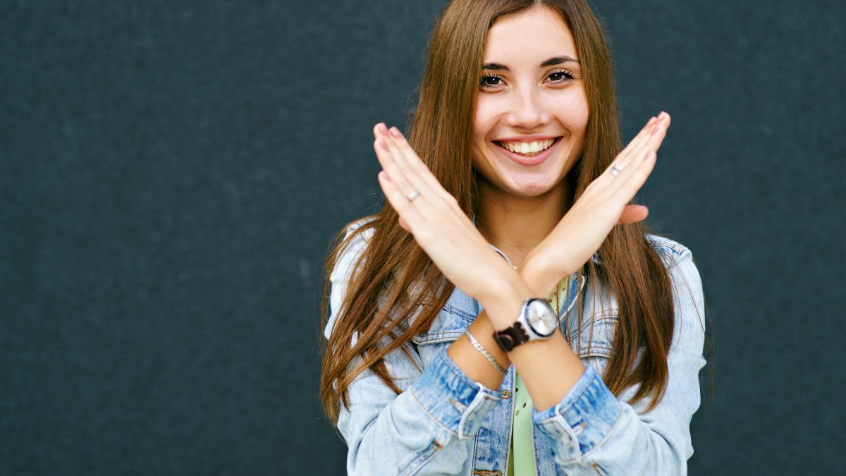 Young woman smiling and crossing her arms to form an 