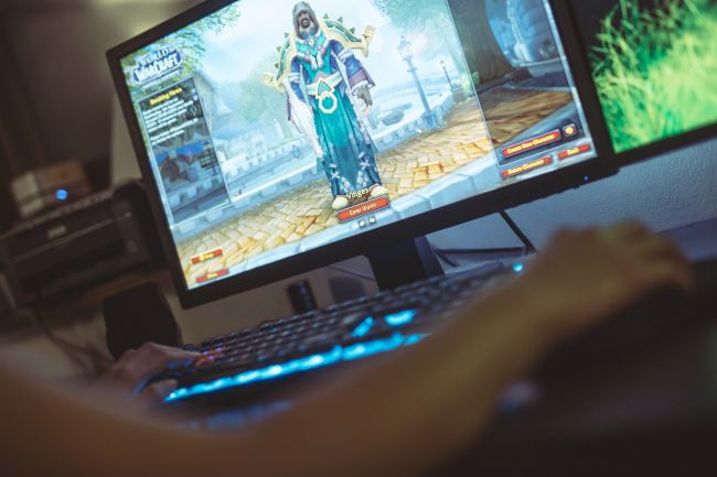 Woman playing World of Warcraft on a desktop PC.