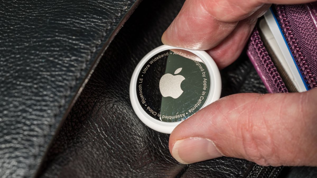 Closeup of an Apple AirTag being placed in someone's leather purse.