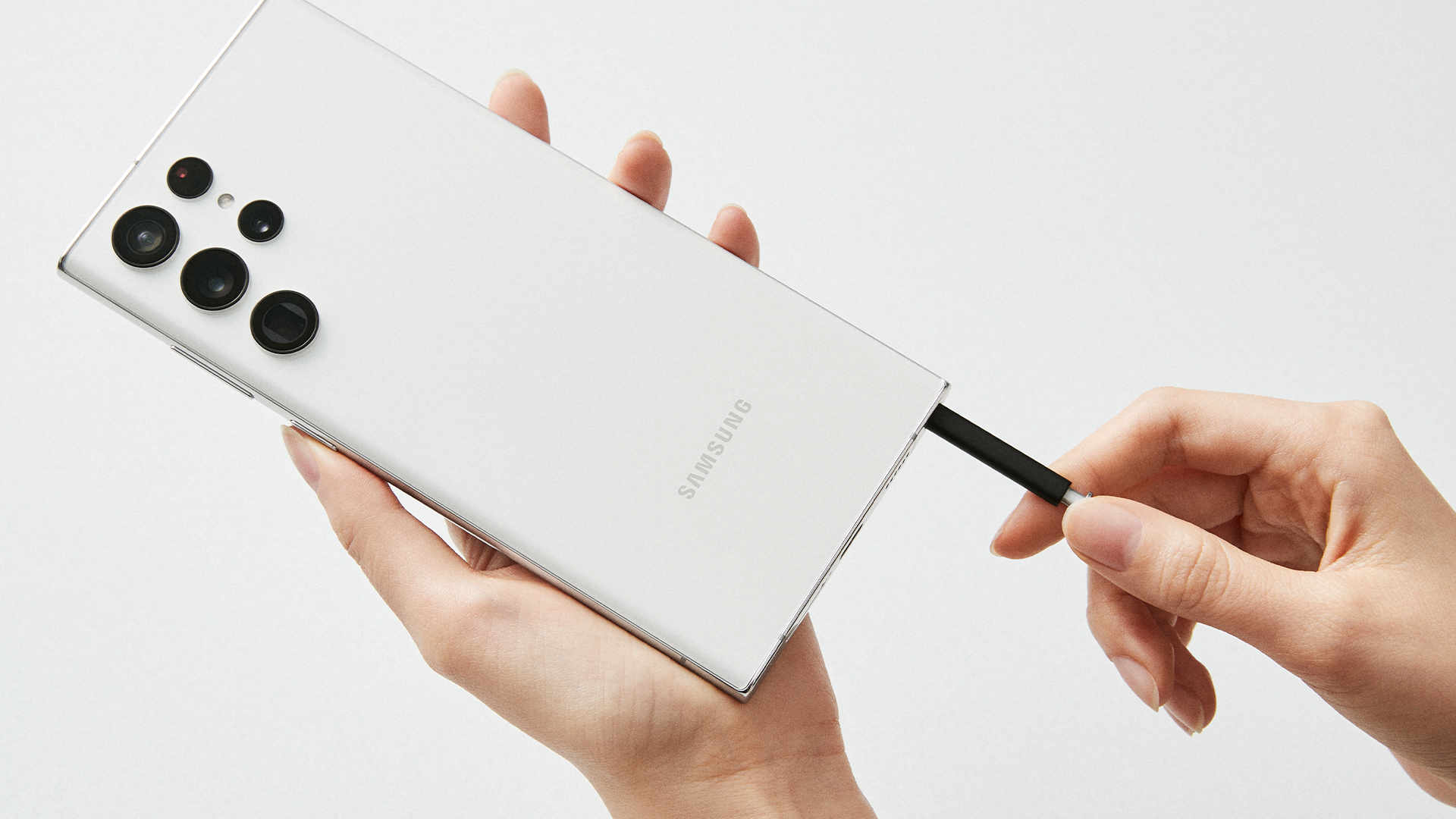 The Samsung Galaxy S22 Ultra in white with its S Pen.