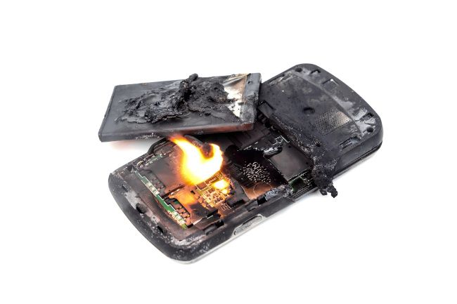 A burning mobile phone with an exploded battery.