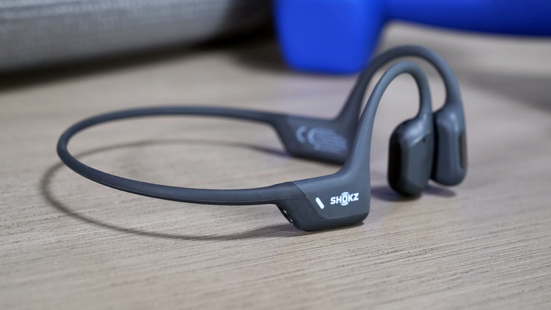 The Shokz OpenRun Pro bone conduction headphones view from the right, sitting on a table