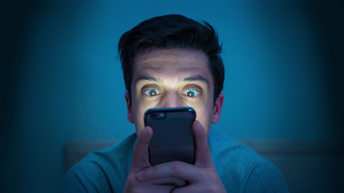 Fearful man looking at smartphone