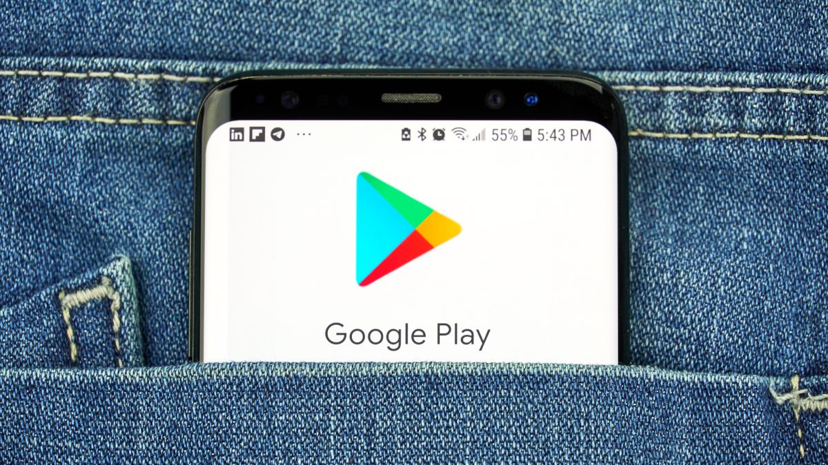 Top of a smartphone in a person's jean pocket, showing the Google Play logo.