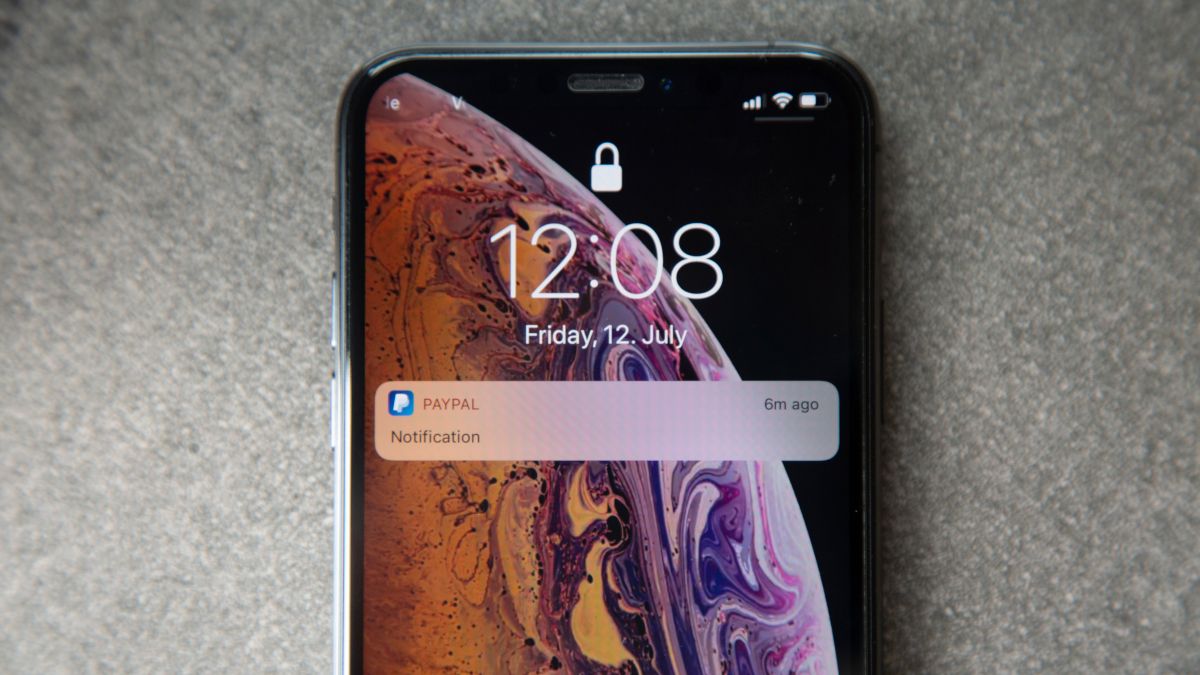 An iPhone's lock screen with a PayPal notification.