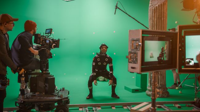 A person in a motion capture outfit being filmed in a movie studio.